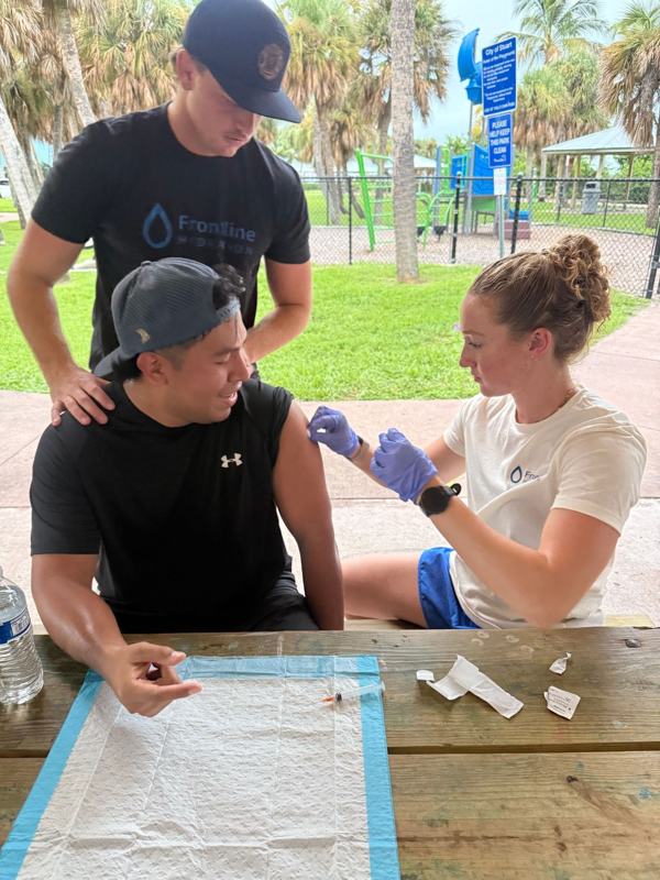 Frontline provider giving a vitamin shot at a park event in Stuart